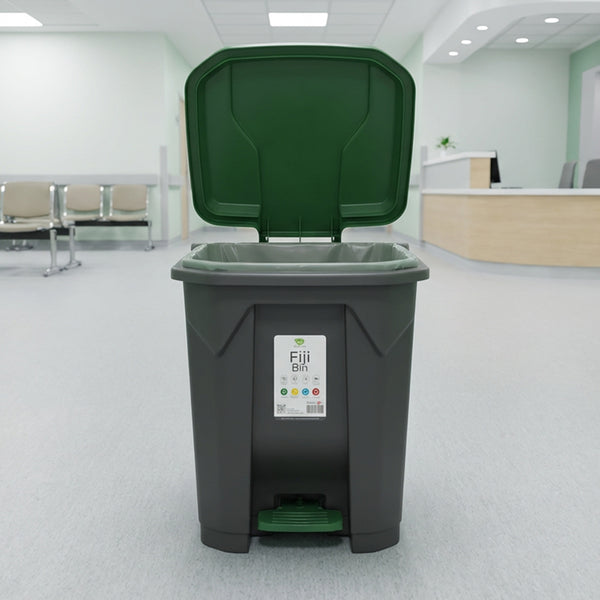 Green and gray trash bin with a label in an indoor setting